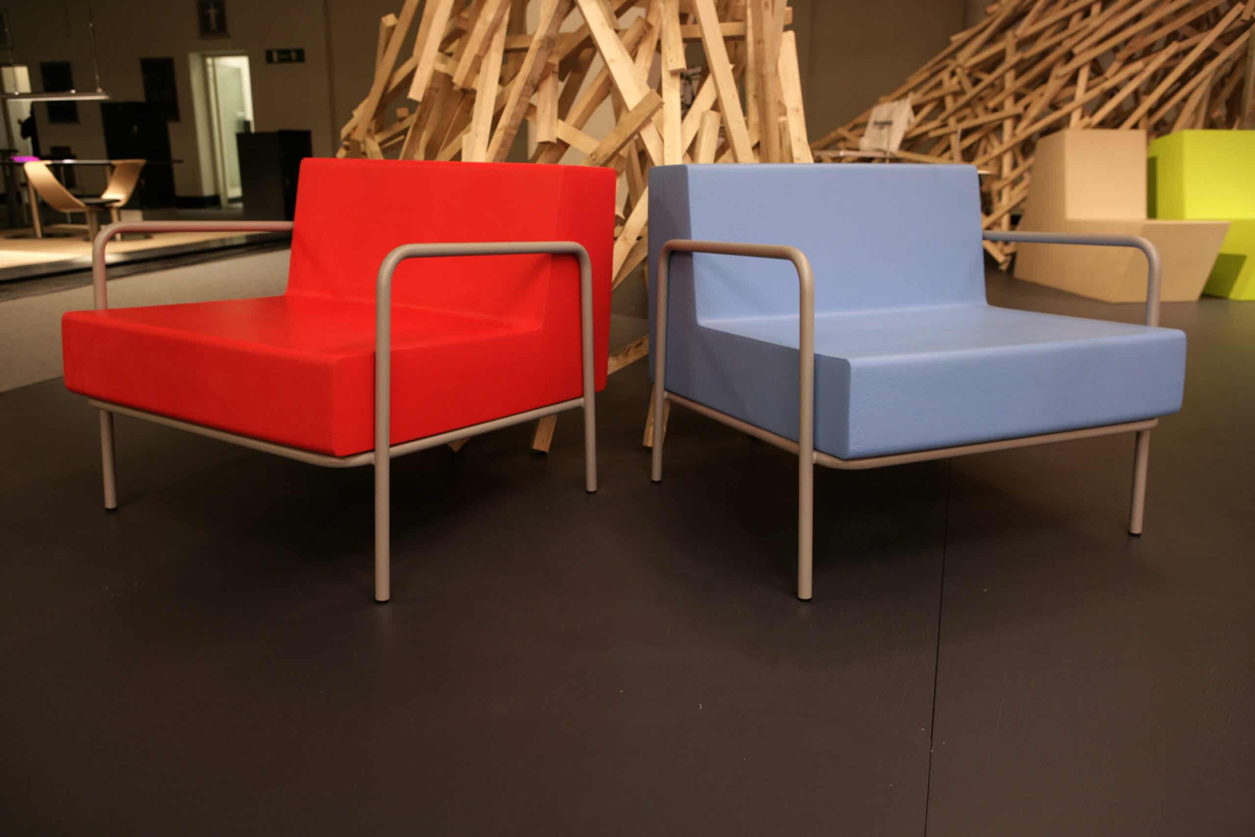 Red and blue Frame armchairs in a design exhibition
